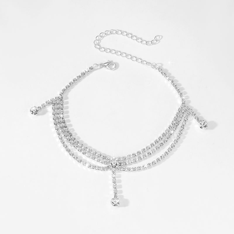 Silver necklace with clear stones on a light gray background